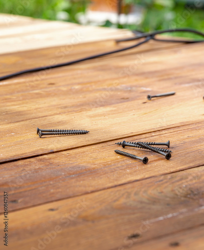 Foto Pile of screws on a wooden table