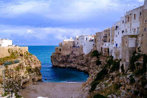 A quaint small town perched on a cliff that overlooks a beautiful body of water