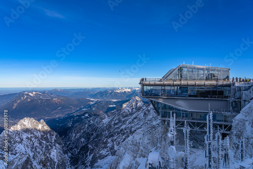Stunning view of the Alps with the panorama platform on German side on top of Zugspitze, on a sunny winter day with blue sky and cloud, Garmisch-Partenkirchen, Bavaria, Germany