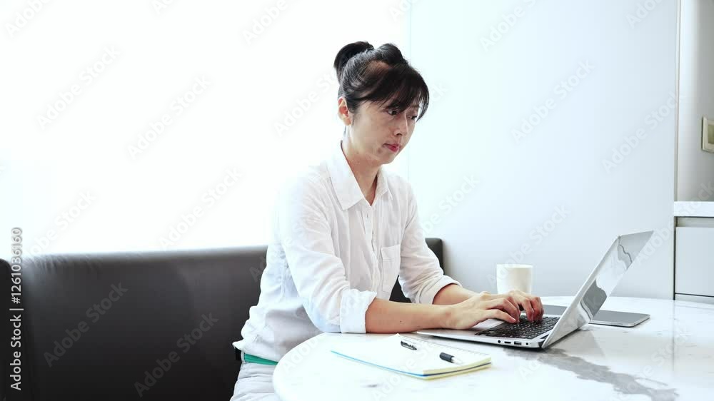 Young beautiful woman using laptop writing notes in notebook at home