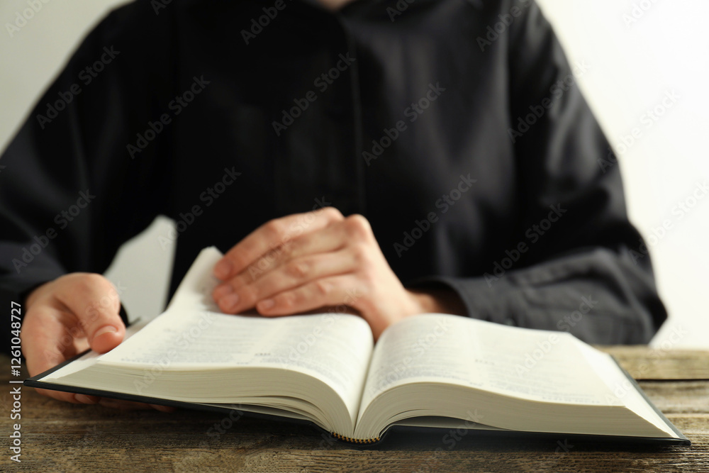 Woman reading Holy Bible at wooden table, closeup Woman reading Holy Bible at wooden table, closeup