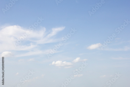 A view of a hazy blue sky featuring clouds in a spotted design.