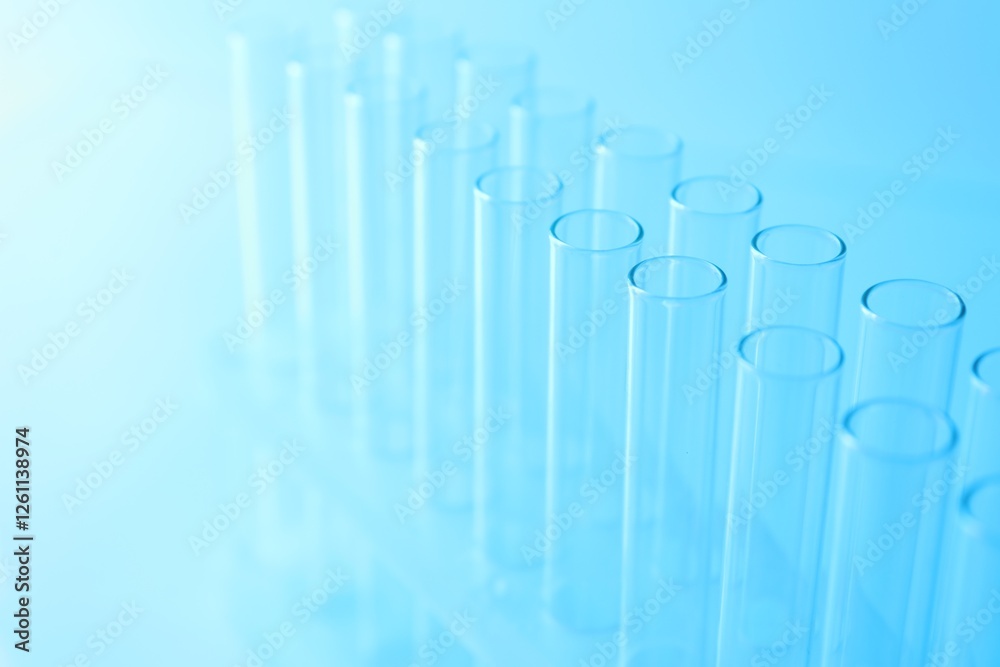 Empty test tubes on light blue background, closeup. Laboratory glassware Empty test tubes on light blue background, closeup. Laboratory glassware