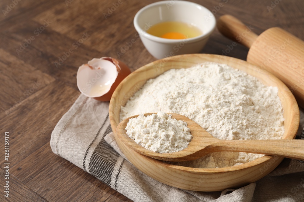 Rolling pin, flour and yolk on wooden table, closeup Rolling pin, flour and yolk on wooden table, closeup