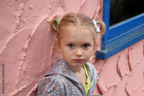 Portrait of a Little Girl with Pigtails in Front of a Textured Wall