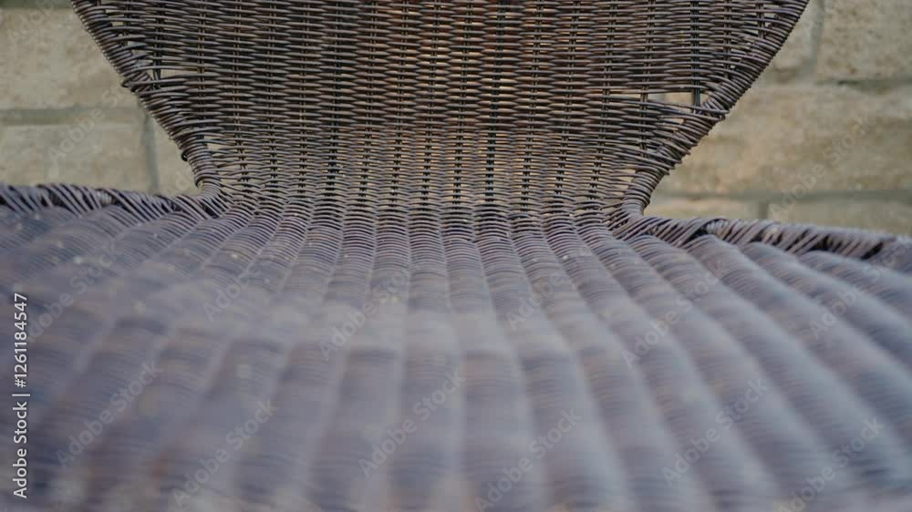 Intricate close-up view of a wicker chair highlighting its texture and pattern. Ideal for themes of comfort, outdoor furniture, and craftsmanship. Wicker Chair with Focus on Texture and Pattern