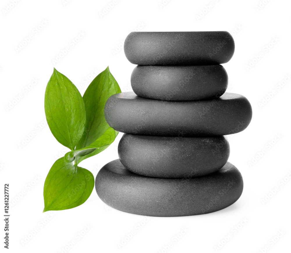Fototapeta premium Stacked spa stones and green leaves isolated on white