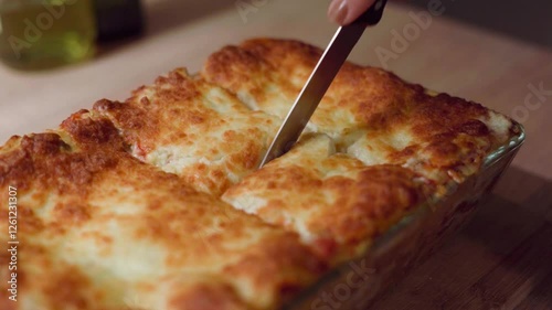 Anonymous hand cutting delicious lasagna in slow motion