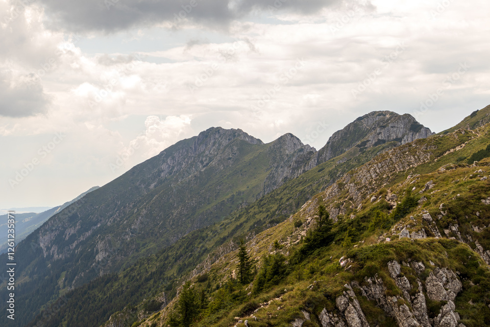 hills and mountain peaks full of vegetation, before summer, under a clear sky full of rain clouds hills and mountain peaks full of vegetation, before summer, under a clear sky full of rain clouds