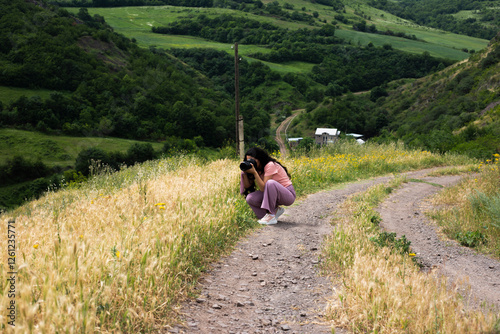 woman photographing road  in forest photo