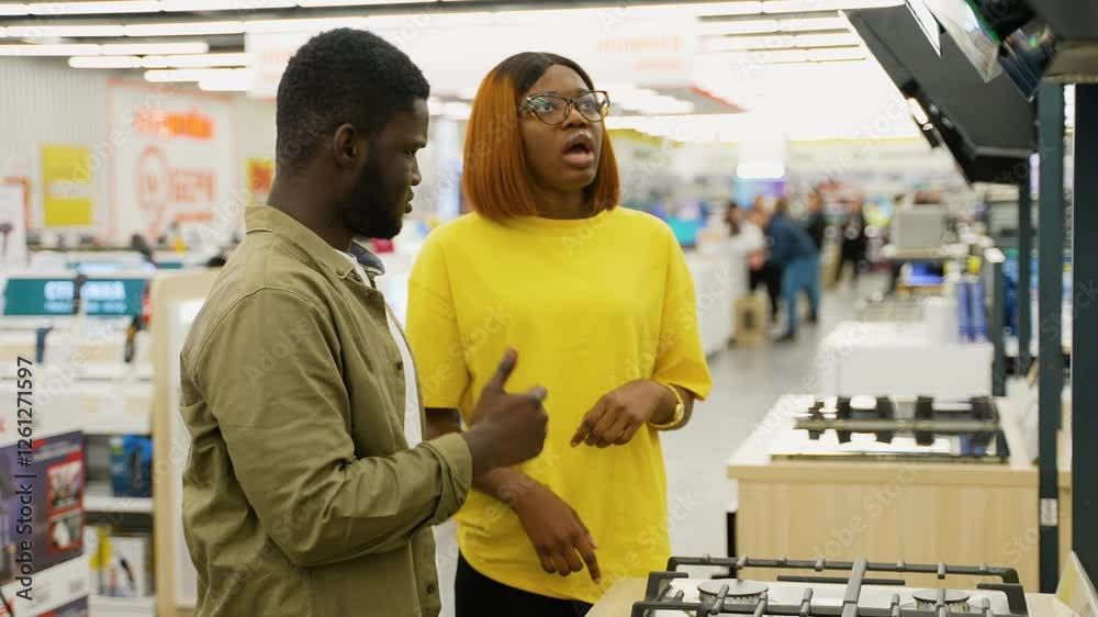 African American couple arguing while choosing a gas stove African American couple arguing while choosing a gas stove