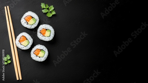 Sushi rolls on dark background with chopsticks, top view