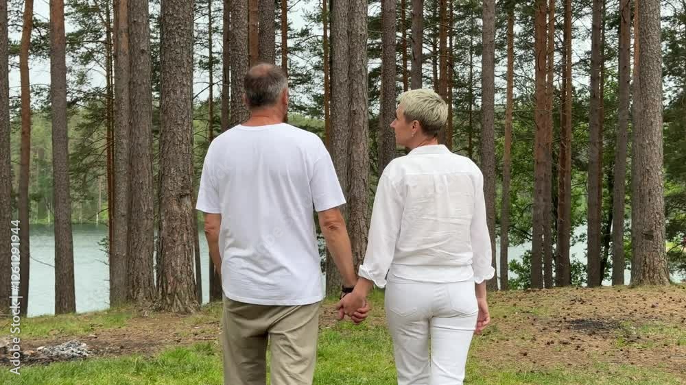 Beautiful and happy elderly couple man and woman relaxing in nature. Love story concept, adults in love at summer Beautiful and happy elderly couple man and woman relaxing in nature. Love story concept, adults in love at summer