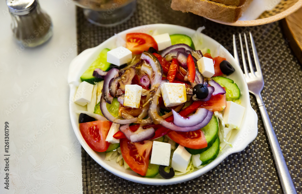 Plate of tasty Greek salad with fresh cucumbers, tomatoes, bell pepper and feta cheese Plate of tasty Greek salad with fresh cucumbers, tomatoes, bell pepper and feta cheese