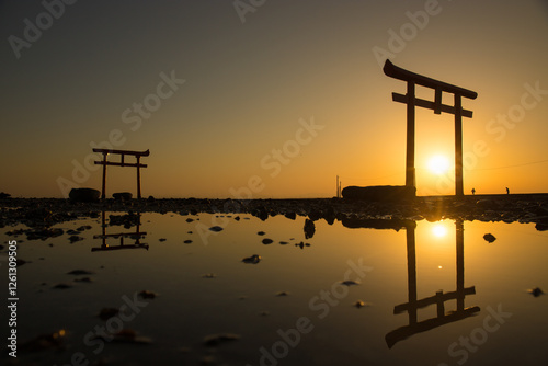 Wide shot of water torii and its reflection at a dawn