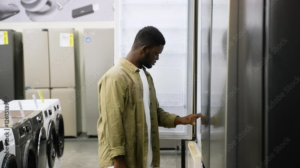 Man inspecting a refrigerator in appliance store sale