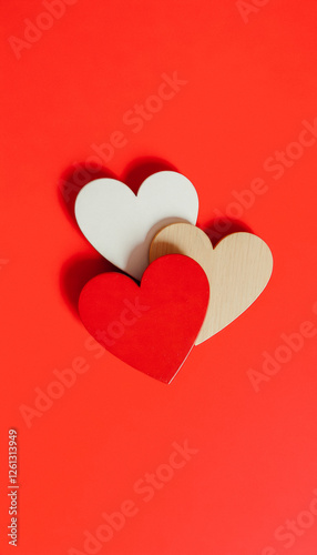 Wallpaper Mural Two wooden hearts, one red and one natural, placed on a red background, symbolizing love and unity for Valentine's Day Torontodigital.ca