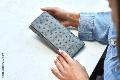 Obraz na płótnie Elegant female hands holding gray leather wallet with ostrich texture on marble table, fashion and style concept w salonie