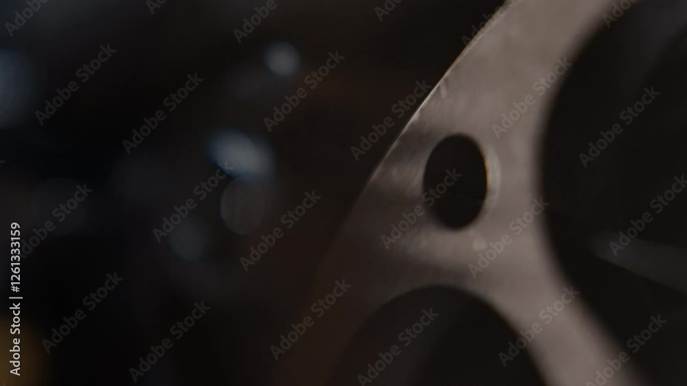 Close ups of a vintage 8MM projector spools moving and playing film 