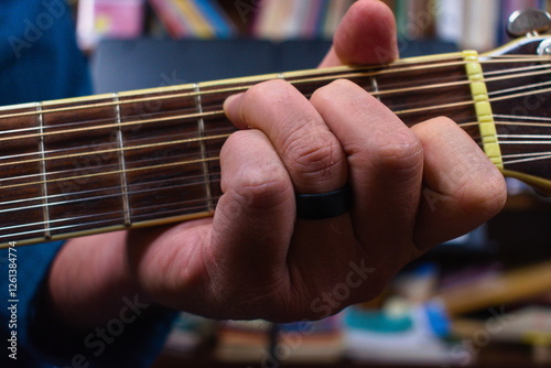 Fotografie A Hand Forming a Chord on a Guitar