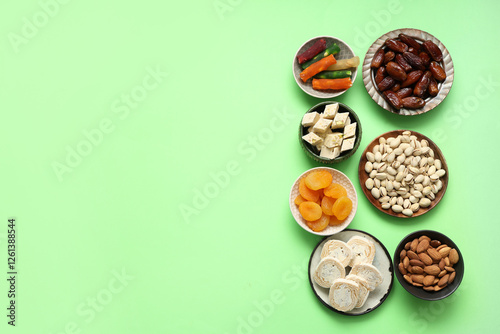 Plates with different Eastern sweets for Ramadan on green background photo