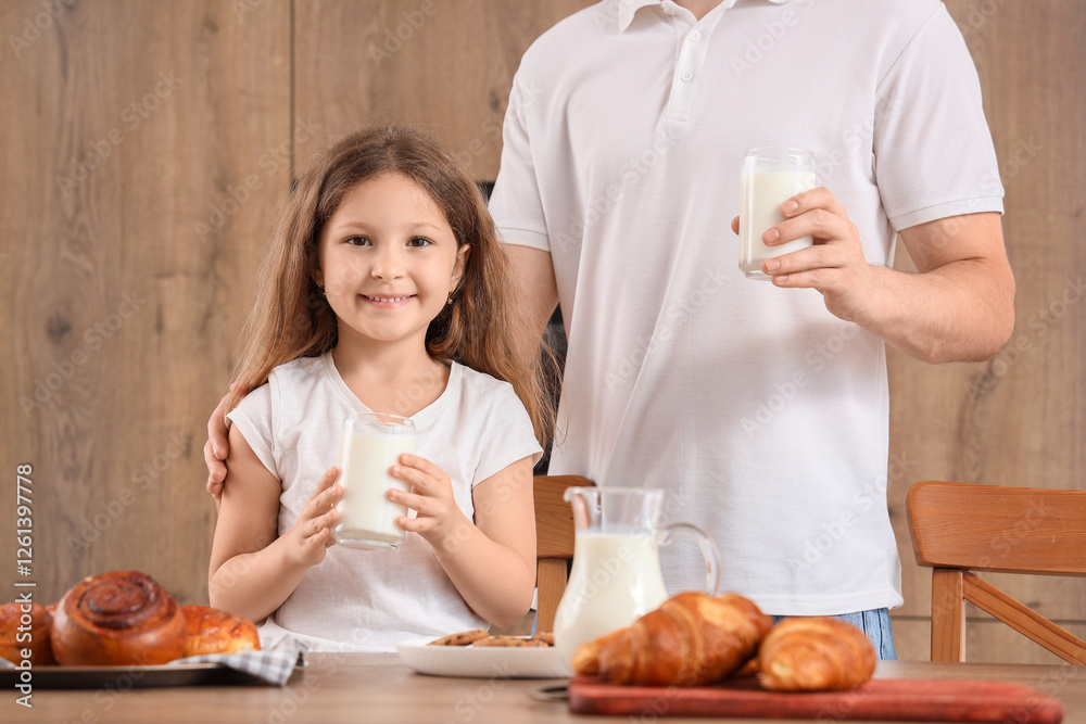 Little girl and her father with glasses of milk in kitchen Little girl and her father with glasses of milk in kitchen