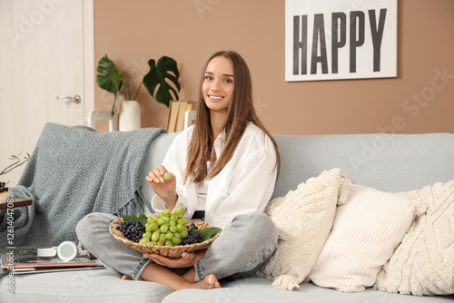 Young woman with grapes sit...