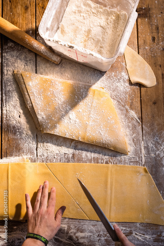 Artisan Craft: Hand-Cutting Fresh Pasta Dough on Wooden Table