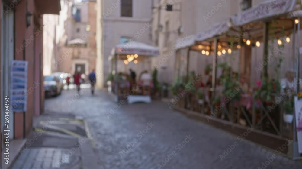 Blurred street scene in rome features people walking on cobblestone and dining outdoors with vintage buildings in the background during daytime creating a bokeh effect. Blurred street scene in rome features people walking on cobblestone and dining outdoors with vintage buildings in the background during daytime creating a bokeh effect.