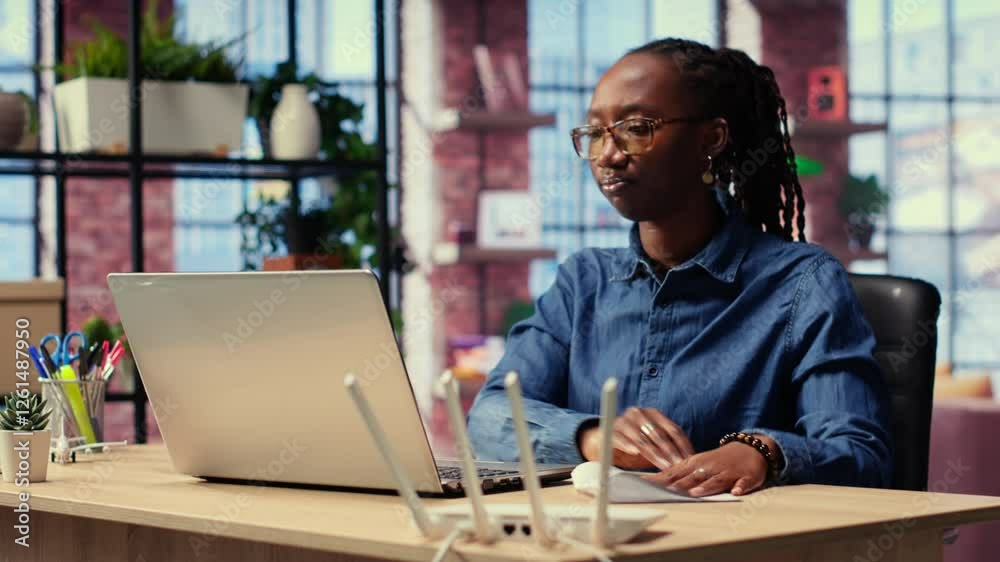 Irritated African American girl struggling to reach the internet provider to help fix the signal loss issues, freelancer working at home with an unstable Wi Fi connection. Camera B.