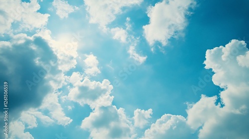 A vibrant blue sky with fluffy white clouds creating a dynamic abstract pattern