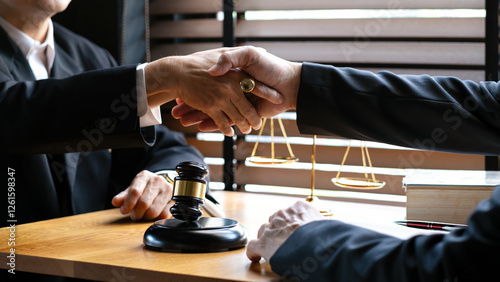 Wallpaper Mural Close-up of two business professionals shaking hands over wooden desk with gavel, scales of justice, and legal books, agreement, legal consultation, or business negotiation Torontodigital.ca