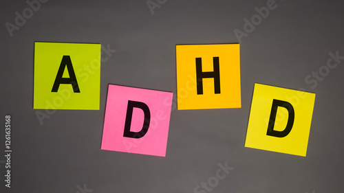 ADHD or attention deficit hyperactivity disorder text letter message on colorful sticky notes isolated on grey background photo