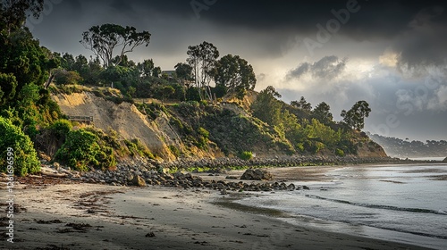 Serene coastal landscape with rocky shore, lush vegetation, and dramatic cloudy sky at dusk