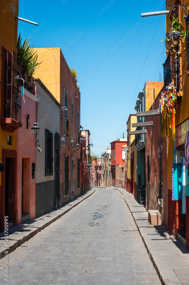 Fototapeta premium Colorful Colonial Street and Road of San Miguel de Allende Mexico. Mexican streets with colorful houses of all colors in the sunshine