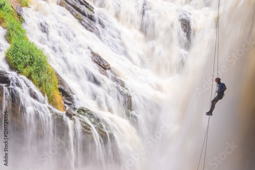Fototapeta Naklejka Na Ścianę i Meble -  Long exposure photo of a man in front of a waterfall in Tombos, Minas Gerais.