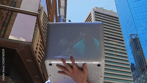 Asian businessman using laptop outside the office building in Hong Kong