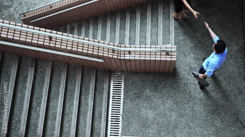 Top view of businesswoman and businessman shaking hands on staircase