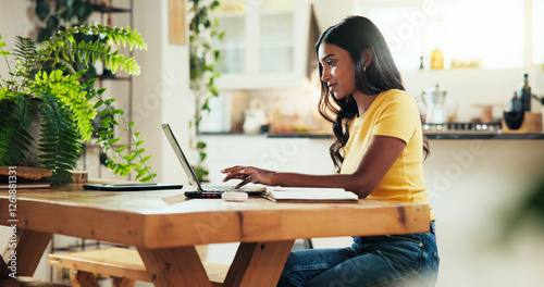 Fotografie Woman, student and typing with laptop in kitchen for online course, elearning or class schedule at home