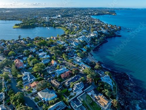 Coastal suburbia, New Zealand. Houses and streets, nestled beside the ocean. Aerial view. TAKAPUNA, AUCKLAND, NZ