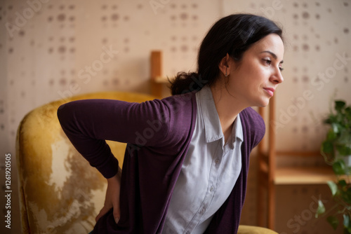 Woman rubbing aching back photo