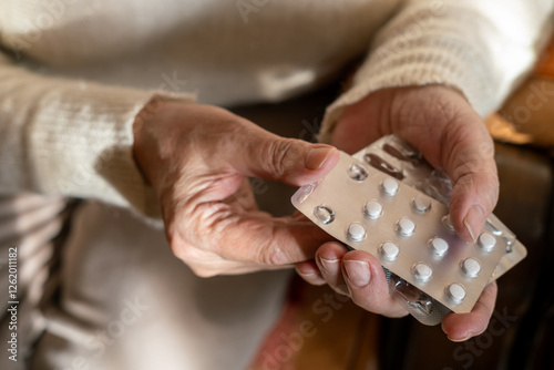 Old woman 70s taking white pill. Grandmother putting tablet. Close up.