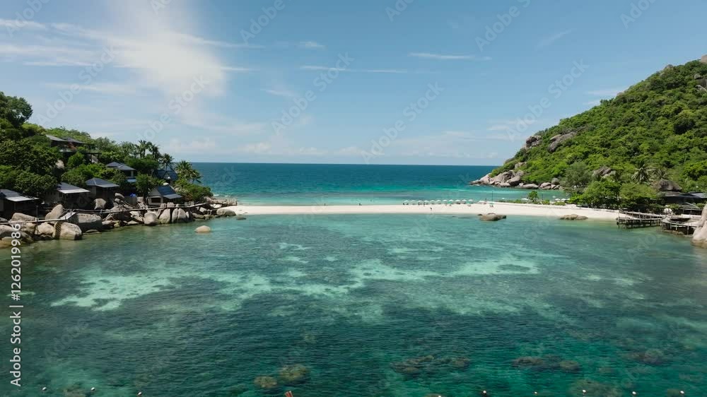 Wooden boat floating in crystal clear water near a sandy beach surrounded by green hills. Nang Yuan, Koh Tao, Thailand. Wooden boat floating in crystal clear water near a sandy beach surrounded by green hills. Nang Yuan, Koh Tao, Thailand.