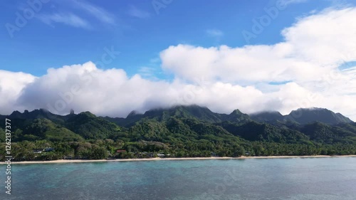 A beautiful time-lapse showcasing the mountains and coastline of Rarotonga, Cook Islands. Transition of clouds and vibrant tropical scenery under a bright blue sky