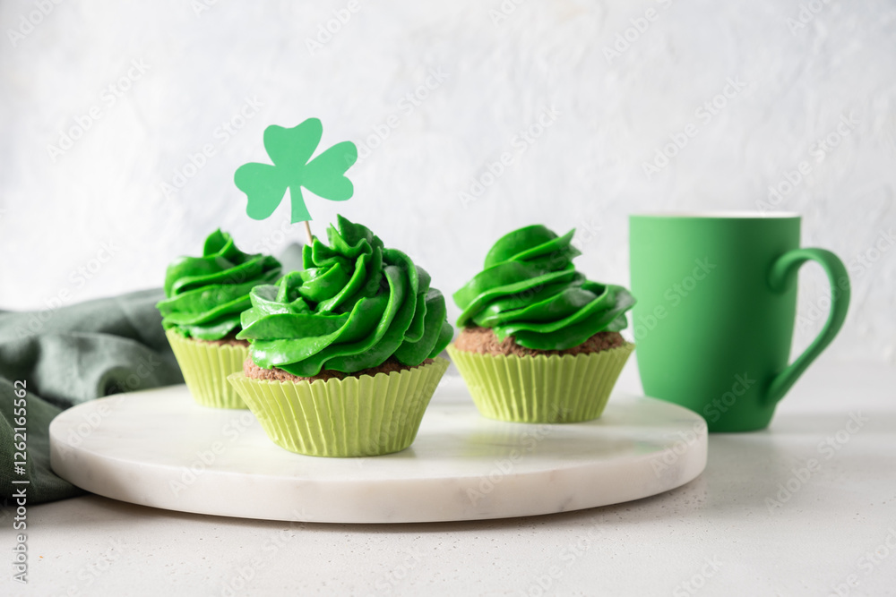 Homemade chocolate cupcakes with green whipped cream on white background for St. Patrick's Day. Close up.