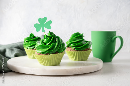 Obraz na płótnie Homemade chocolate cupcakes with green whipped cream on white background for St. Patrick's Day. Close up. w salonie
