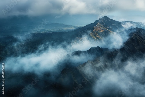 Clouded mountain peaks rise majestically in the Kauai wilderness under a blanket of mist and cloud, Aerial clouded mountain Peaks Kauai Wilderness interior Hawaii