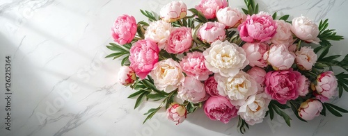 A bouquet of pink and white flowers is arranged on a white table