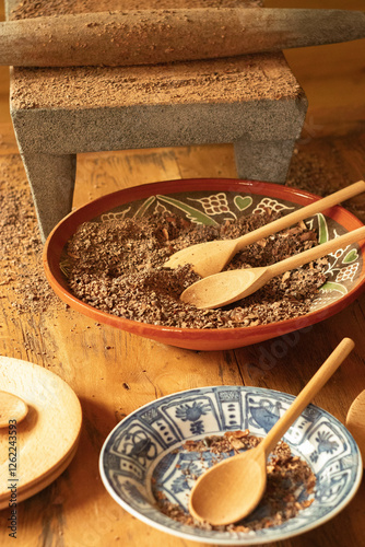 ground spices on a ceramic plate and a wooden spoon

