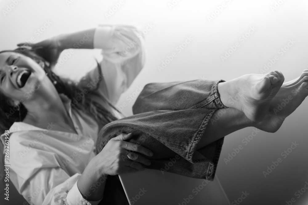 Naklejka premium Beautiful woman in white shirt posing in studio on chair.